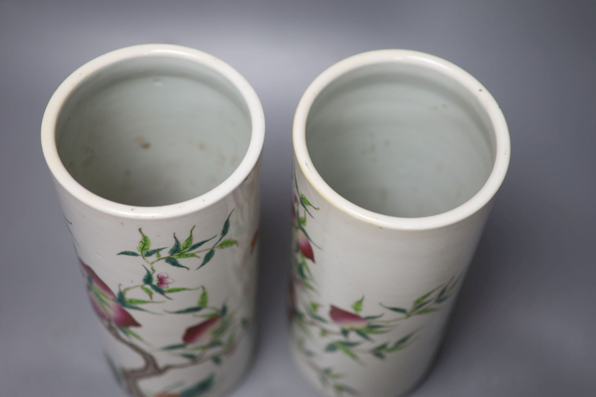 A pair of Chinese famille rose nine peach cylindrical vases, height 28cm